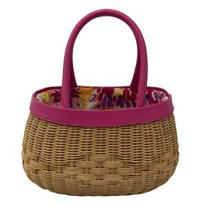 A wicker basket bag with pink handle and floral lining